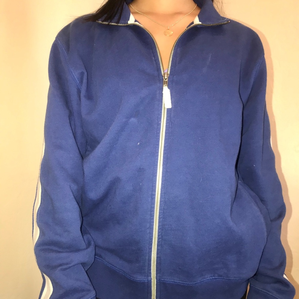 blue zip up jacket with stripes on the sleeves